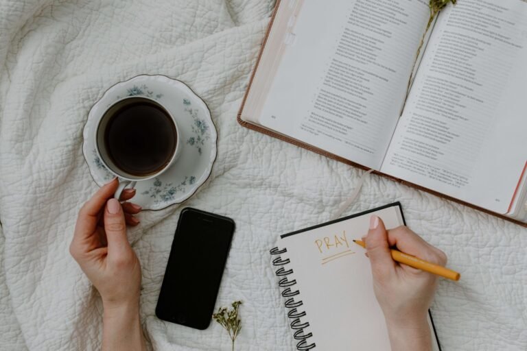 You can see hands writing, a cup of coffee and a volume of poetry on a marble desk.